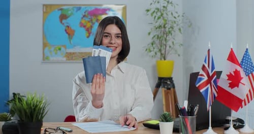 Portrait of a Woman Travel Agent in a Travel Agency with Passports and Tickets