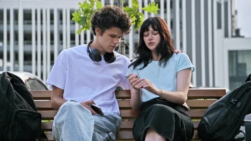 Pareja de amigos adolescentes, hombres y mujeres tristes, sentados juntos en el banco