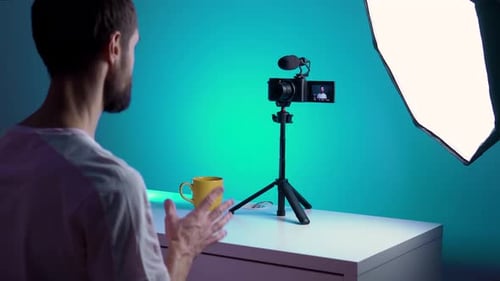 A Young Blogger Records a Video with Himself on His Camera in His Studio