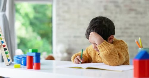 Niño, dibujando o niño escribiendo los deberes en un cuaderno en la educación infantil para el desarrollo del crecimiento