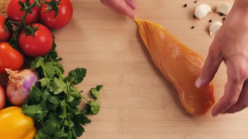 Man Slicing Raw Turkey or Chicken Meat Fillet on Oak Cutting Board Closeup Cooking with Knife on