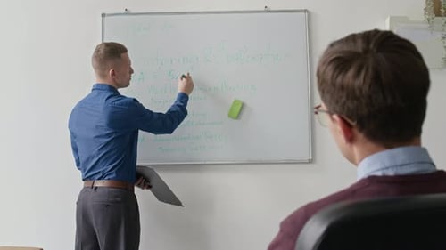 Team Lead Explaining Week Work Plan to Colleagues Presenting at Board in Office