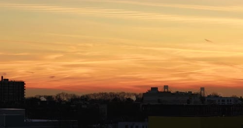 Brooklyn skyline with colorful sunset, smoke and steam coming out of chimneys, and Verrazano bridge