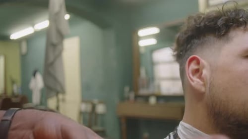 Barber Shaving Beard Neckline of Client with Electric Razor