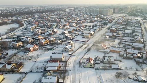 Aerial View of Private Homes with Snow Covered Roofs in Rural Suburbs Town Area in Cold Winter