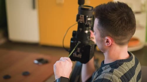 TV Technician Adjusting Camera Lens Preparing for Video Shoot