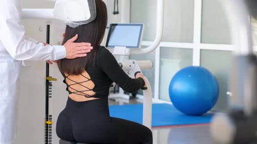 A Male Doctor Examines the Back of a Female Patient Orthopedic Examination