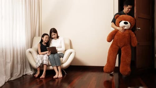 Menina asiática feliz recebendo um grande brinquedo e presente de sua família