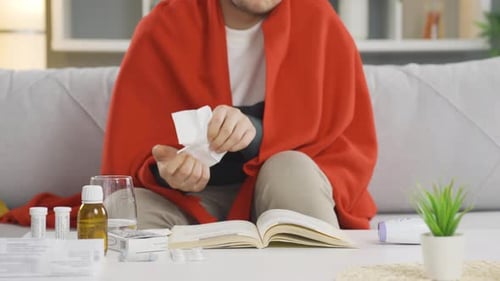 Un joven con gripe estornuda.