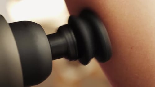 Person Massaging Triceps with Percussion Massager Joint Pain Relief Therapy and Muscles