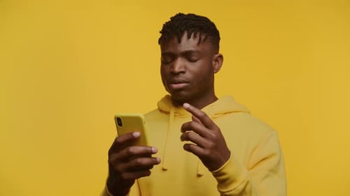 Young Black Man Reacting to Smartphone Content