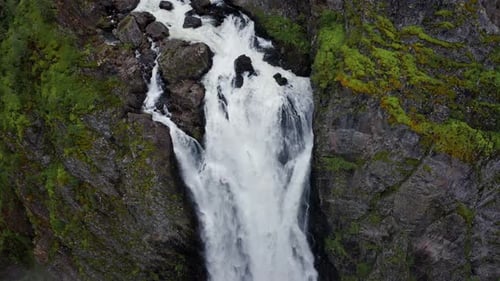 Voringfossen Waterfall and Cliffs with Green Trees in Norway at Sunny Summer Day