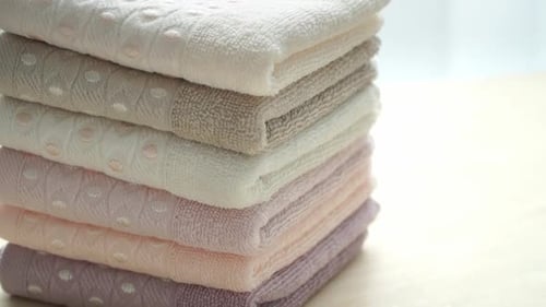 Closeup of Stack of Cotton Terry Clean Folded Towels Rotate on Board