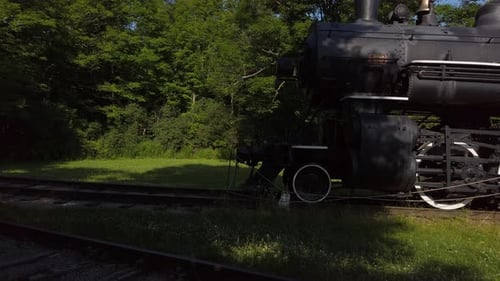 Wide panning shot from train tracks over to an old steam locomotive
