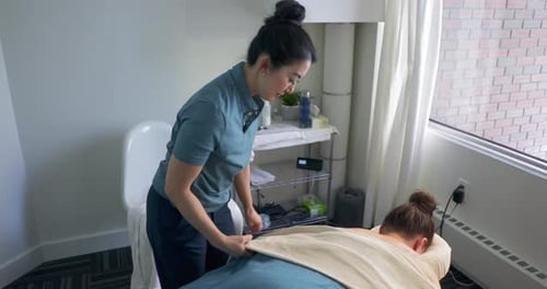 Massagista prepara tratamento de terapia natural para cliente em clínica no Canadá