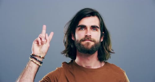4k video footage a man showing the peace sign against a grey background