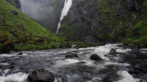 Voringfossen Waterfall and Cliffs with Green Trees in Norway at Sunny Summer Day