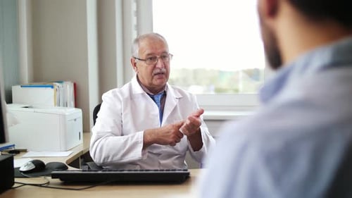 Concepto de medicina, atención médica y personas: médico sénior que habla con un hombre joven