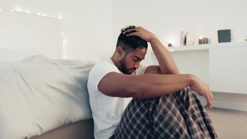 Depression, anxiety and stress with man in bedroom for frustrated, problem and lonely