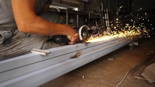 Professional Repairman Sawing Metal Construction with a Circular Saw at Garage Young Male Craftsman