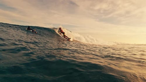 Man Surfs the Wave in the Maldives at Sunset and Sprays Water Into the Camera After Sharp Turn
