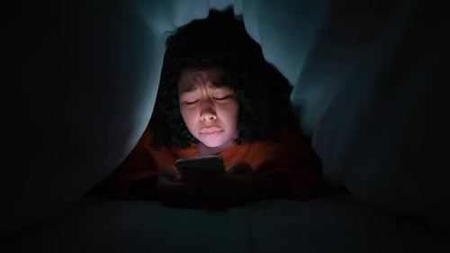 African American Woman Hiding Under Blanket From Thunderstorm Lightning at Night