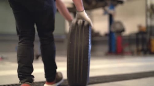 Mechanic man change a wheel tire and service maintenance the suspension of a vehicle