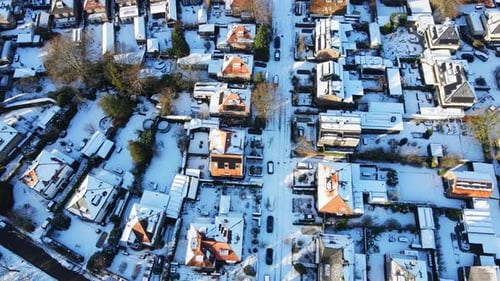 Aerial of snow covered and clean streets in a wealthy suburban neighborhood on a sunny winter day