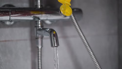 Wasser und Gel in die Badewanne im Waschraum gießen