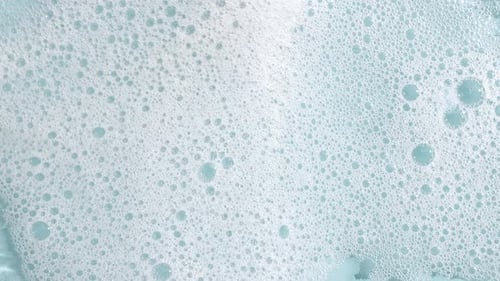 Bubbles of White Soap Foam on a Blue Background Bathtup Soap Foam Texture of Soap Foam Bubbles