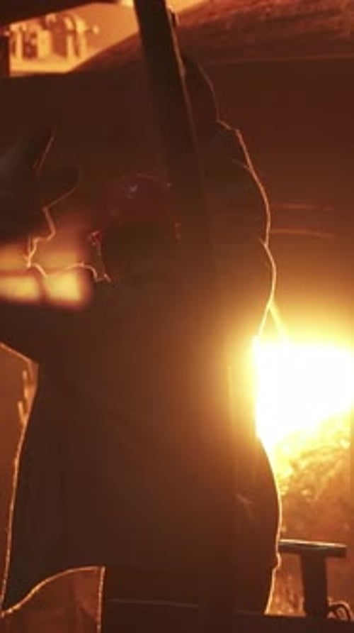 A Dedicated Workers Silhouette Shines in an Industrial Setting Highlighting Their Key Role Stock