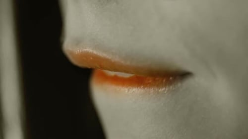 Rouge à lèvres orange sur la bouche d'une jeune fille/d'une adolescente, d'une femme, d'une morsure de la bouche des lèvres/du côté