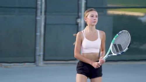 A teenager practicing tennis on a summer afternoon.