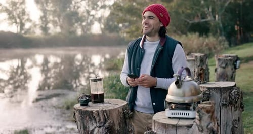Camping, nature and man with coffee and phone in nature on outdoor holiday, vacation and adventure