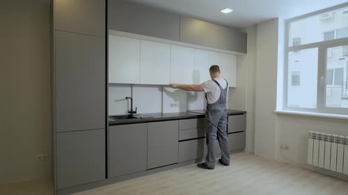 The Builder Checks the Dimensions and Quality of Installation of the Kitchen Furniture Structure