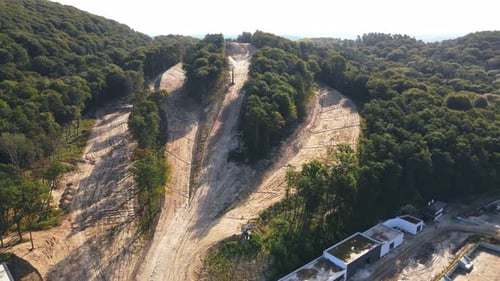 Aerial View Flight Over the Construction of a Ski Slope in the Summer. The Slopes of the Hill Are