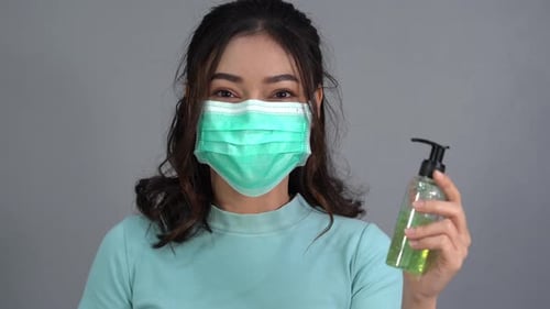 woman in a medical mask(surgical mask) with alcohol gel, coronavirus protection