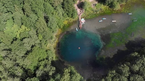 People Tourists Resting Near the Blue Clear Lake and Other People Sailing on Small Boats