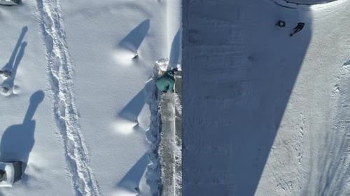 Top View Of People Clearing The Snow From Rooftop And The House Yard On A Sunny Day In Zakopane, Po
