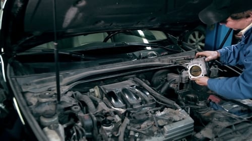 Mechanic Inspecting The Throttle Body