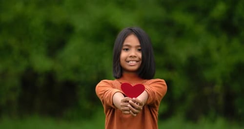 Girl holding red paper hearts