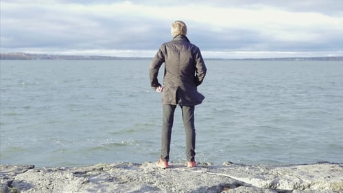 Unrecognizable Traveler Young Man Standing on Coast of Lake and Enjoying View of Nature, Rear View