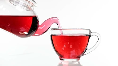 Red Rose Tea in a Glass Teapot and a Cup on a White Background