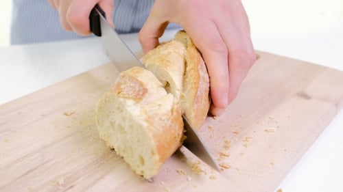 Woman Hands Cutting Bread In Kitchen. Of Female Hands Holding Knife, Slicing White Baguette O