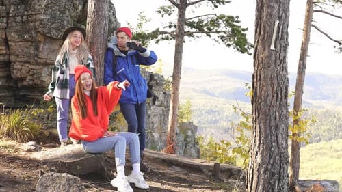 Three Adventurers Have Rest on Head of Mountain