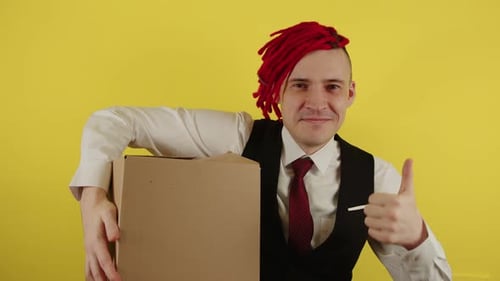 Young Man in White Shirt Vest and Tie with Cardboard Box on Yellow Background in Studio