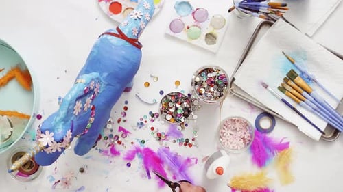 Step by step. Decorating painted paper mache unicorn with paper flowers and jewels.