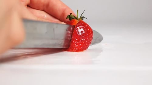 Cut Strawberry on White Surface By Knife