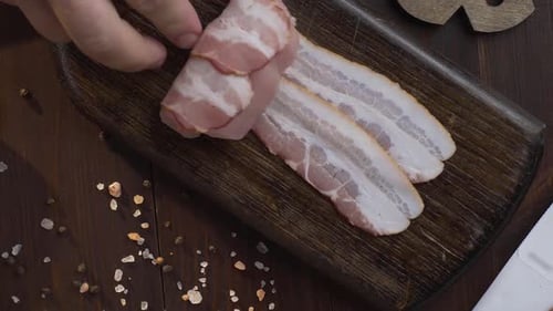 Chef Makes Rolls with Bacon and Chicken Chest on the Dark Wooden Board in the Kitchen, Close Up Shot