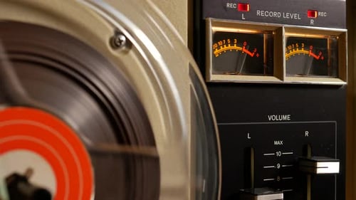 Vintage Reel to Reel tape recorder playing music close up of reel
